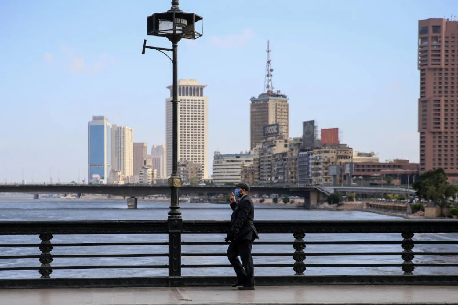 رجل يرتدي كمامة على كوبري قصر النيل بوسط العاصمة المصرية القاهرة (أ.ف.ب)