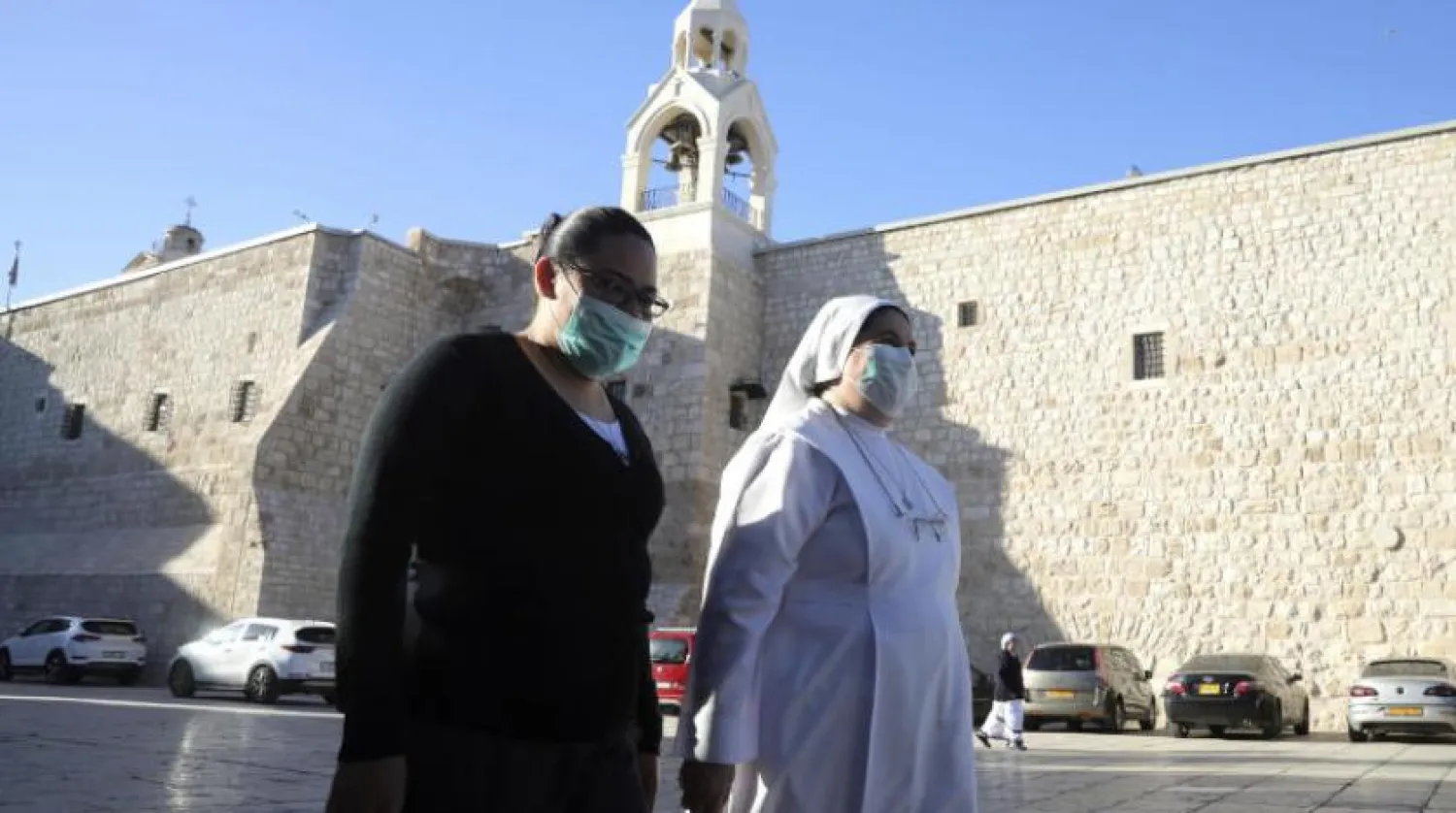 Hristiyanlar, yaklaşık 3 aylık bir aranın ardından yeniden açıldıktan sonra Doğuş Kilisesi'ne gidiyor (AP)
