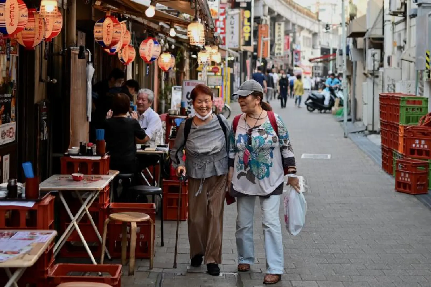 سيدتان تمشيان في أحد شوارع العاصمة اليابانية طوكيو بعد رفع حالة الطوارئ الخاصة بـ«كورونا» (أ.ف.ب)