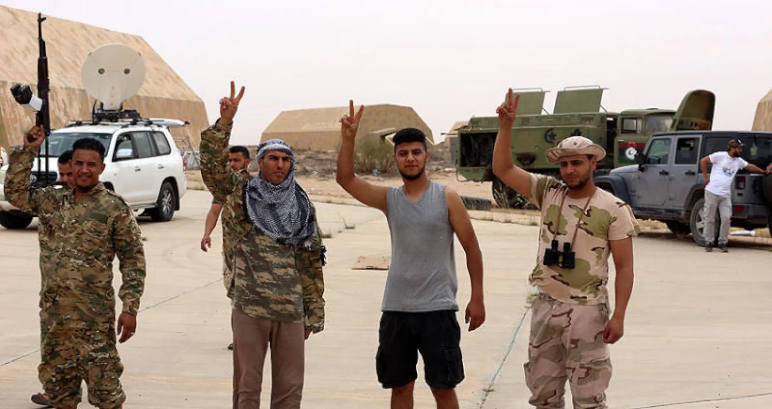 عناصر موالية لحكومة {الوفاق} قرب مدخل قاعدة الوطية الجوية غرب طرابلس (رويترز)