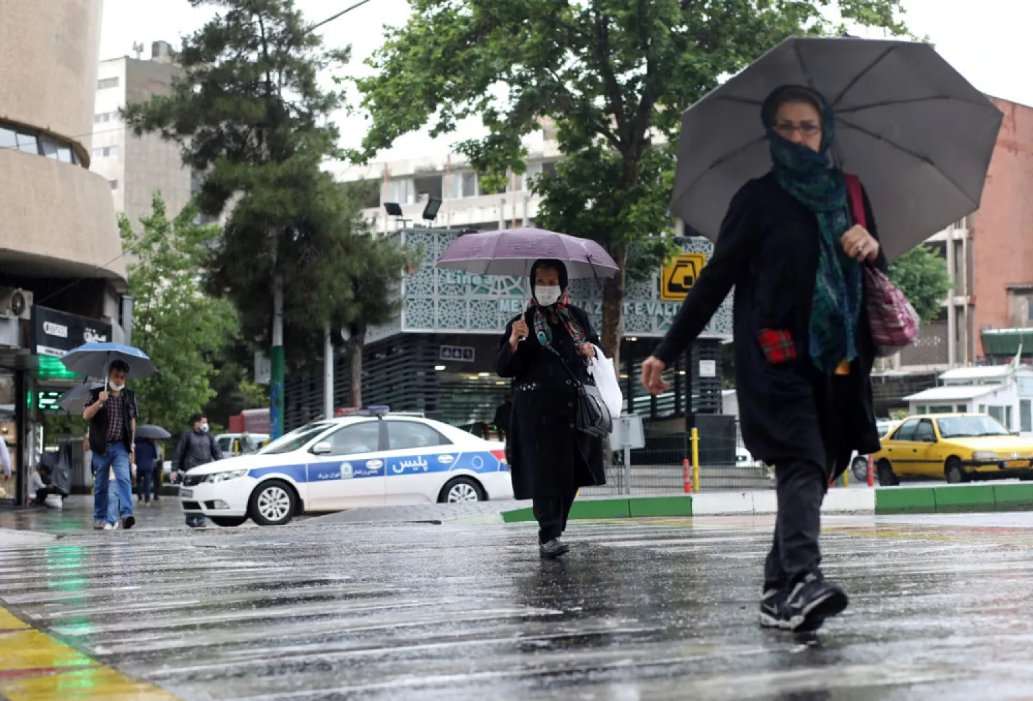 Iranians wear protective face masks, following the outbreak of the coronavirus, as they walk in Vali-E-Asr street, in Tehran, Iran, May 20, 2020. (Reuters)