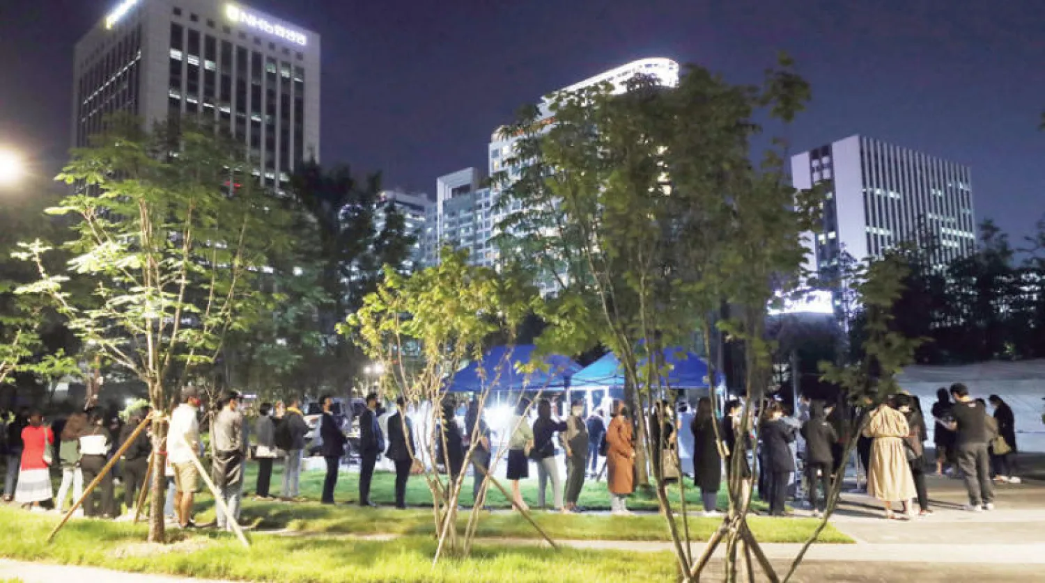 كوريون جنوبيون ينتظرون الخضوع لفحص «كورونا» مساء أمس في سيول (إ.ب.أ)