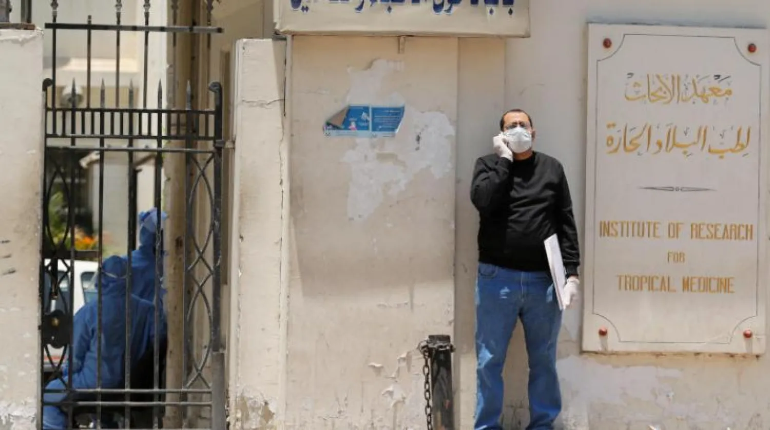 A man wearing protective face mask and gloves stands outside the Institute of Research for Tropical Medicine amid concerns about the spread of the coronavirus disease (COVID-19), in Cairo, in Egypt May 26, 2020. REUTERS/Staff