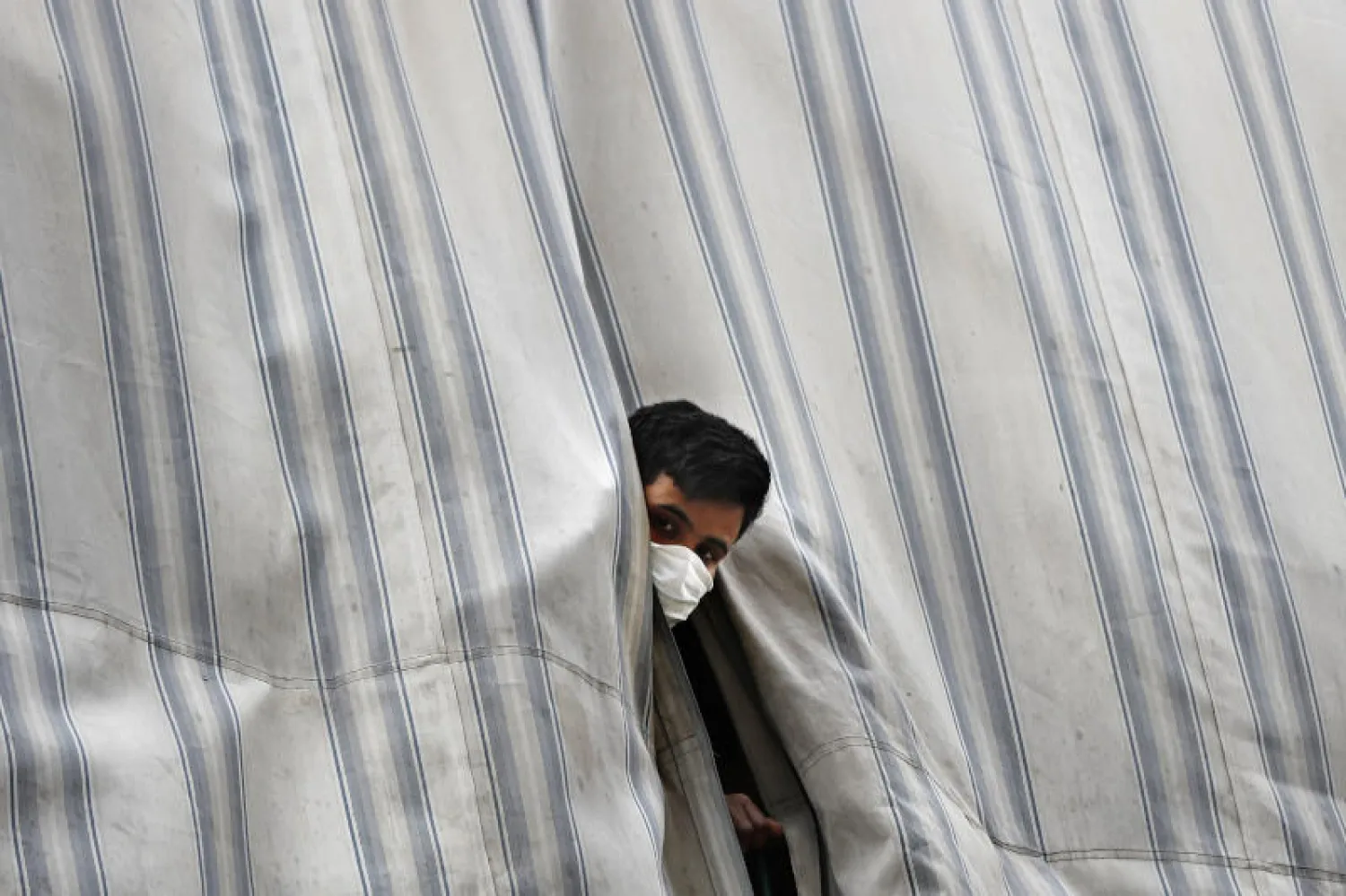 عامل بنغلادشي يطل من شرفة مبنى في بيروت يقيم فيه بنغلادشيون محجورون بعد ظهور إصابات في صفوفهم (أ.ب)