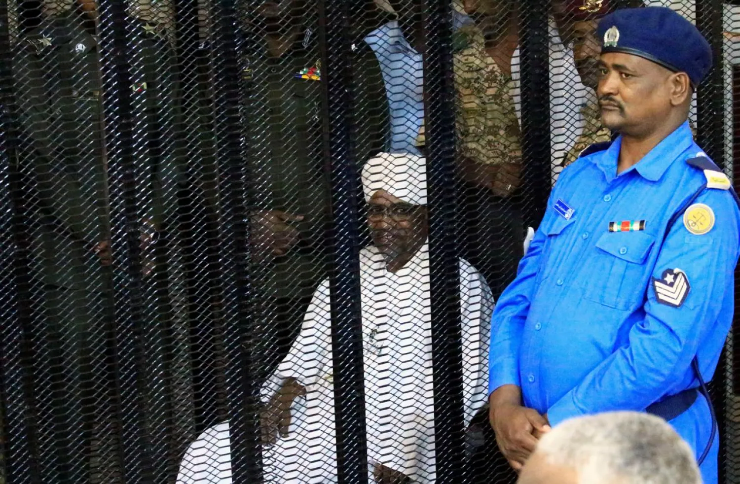 Sudan's former president Omar Hassan al-Bashir sits guarded inside a cage at a courthouse, in Khartoum, Sudan August 19, 2019. REUTERS/Mohamed Nureldin Abdallah
