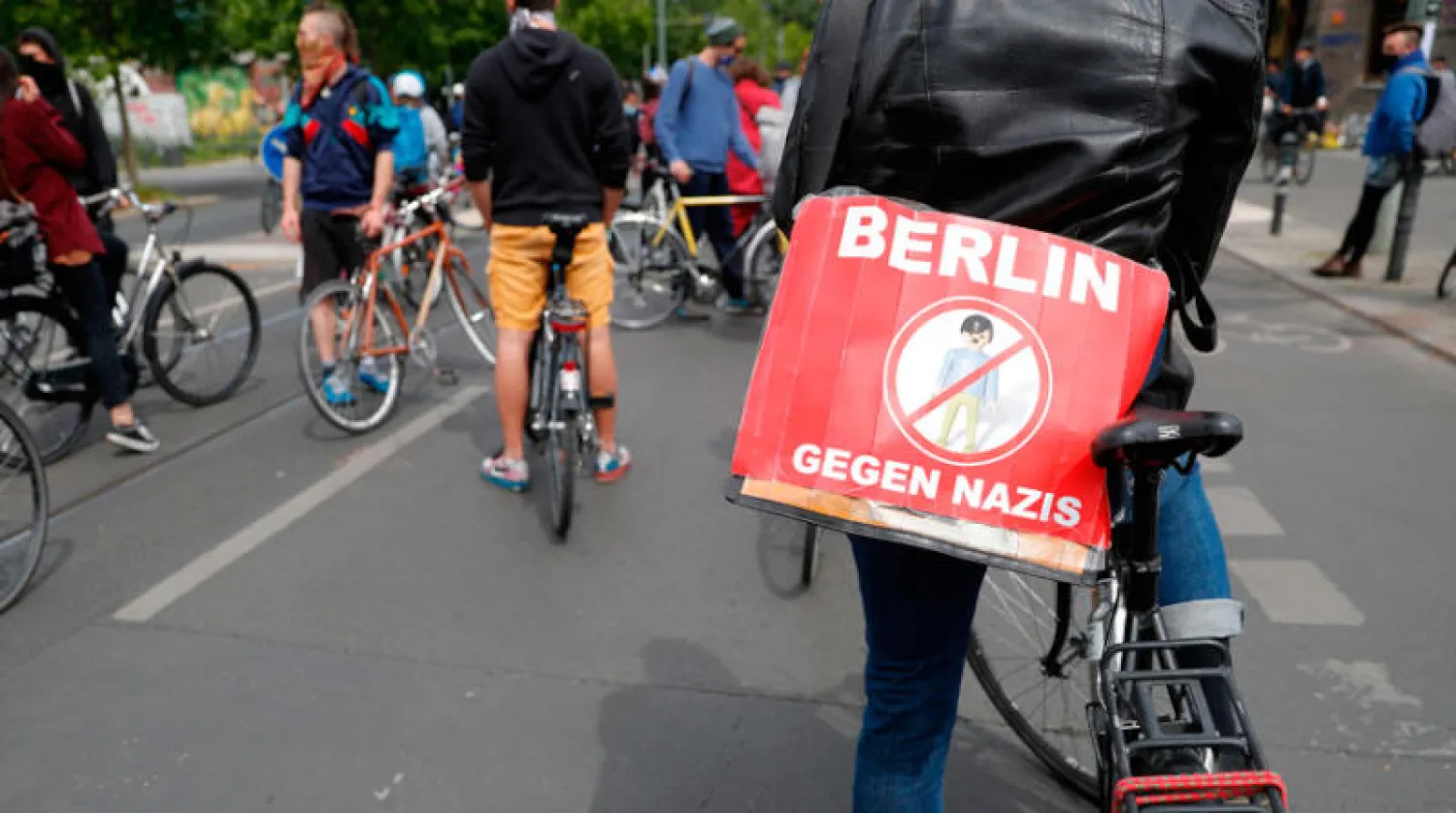 لافتة كتب عليها «برلين ضد النازيين» خلال تجمع لراكبي الدراجات ضد اليمين المتطرف ونظريات المؤامرة في برلين أمس (أ.ف.ب)