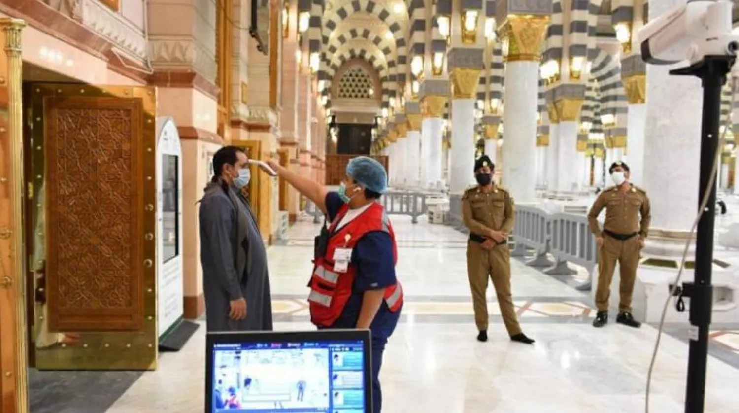 Mescid-i Nebevi kapısında ateş ölçümü yapan görevliler (SPA)