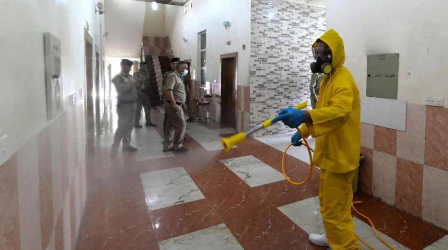 Irak’ın Musul şehrindeki bir karakolda yapılan dezenfekte işlemi (AFP)