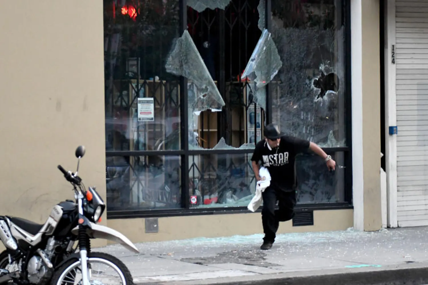 رجل يركض أمام متجر مدمر وسط مدينة كاليفورنيا (د.ب.أ)