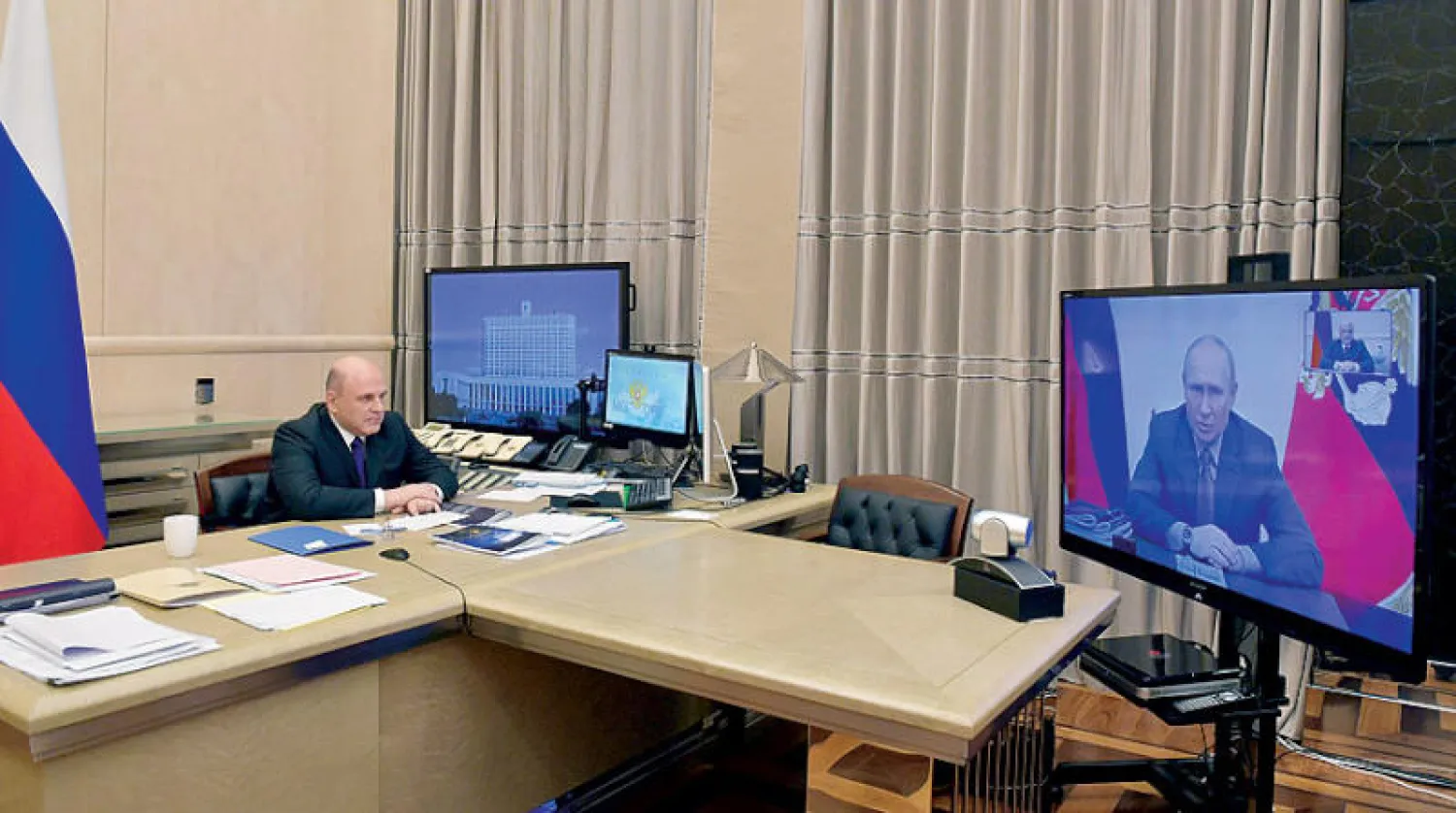 الرئيس الروسي في اجتماع مع رئيس الحكومة عبر الـ«فيديو كونفرنس» أمس (رويترز)