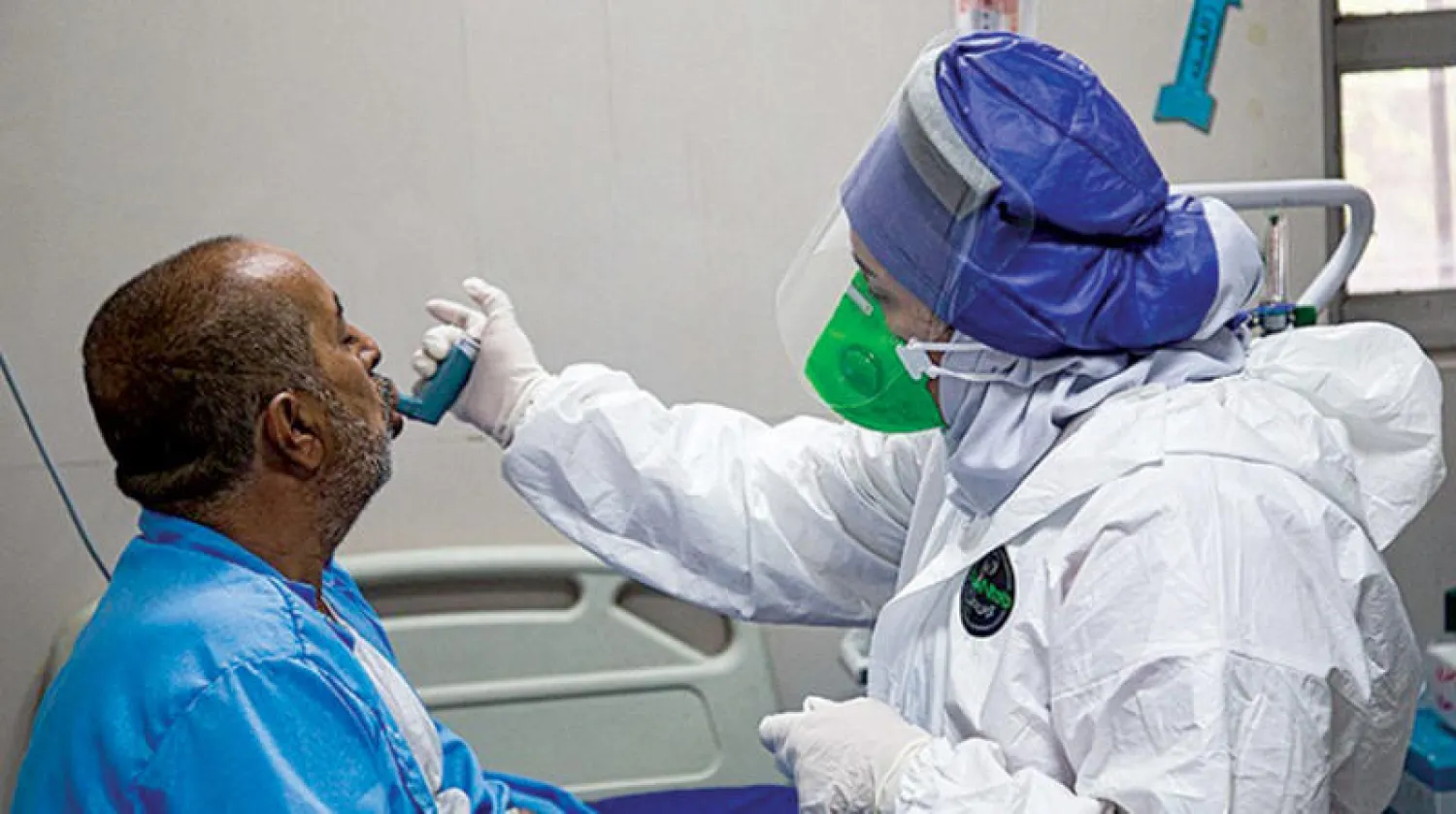 ممرضة تفحص مريضاً بمستشفى رازي المخصص لعلاج إصابات «كورونا» في الأحواز جنوب غربي إيران أمس (تسنيم)