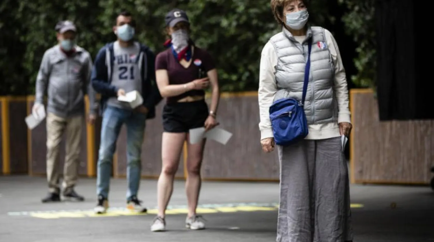 Maske takıp sosyal mesafeyi koruyan kişiler (AP)
