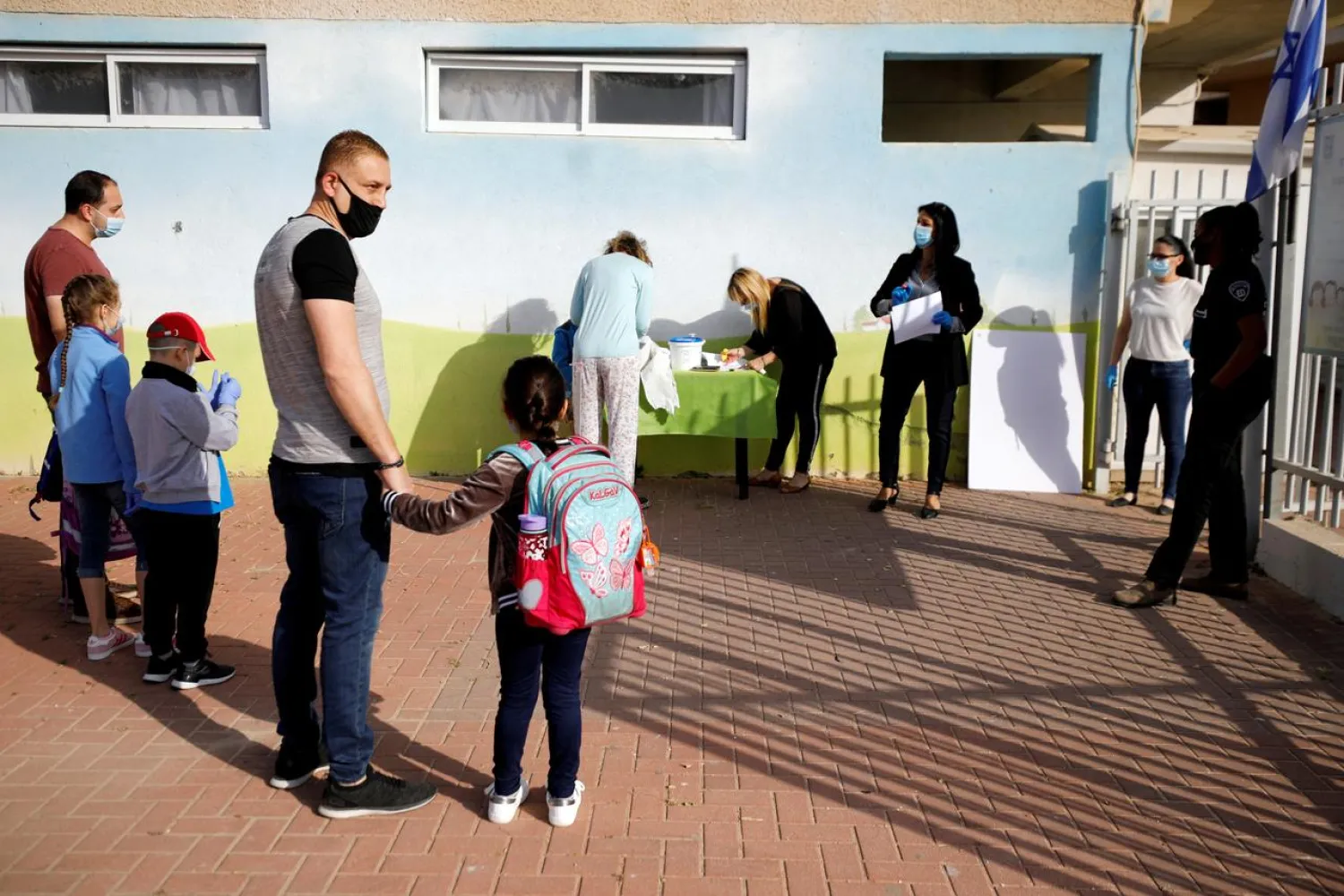 FILE PHOTO: Parents wait with their children to enter their elementary school in Sderot as it reopens following the ease of restrictions preventing the spread of the coronavirus disease (COVID-19) in Israel May 3, 2020. REUTERS/Amir Cohen/File Photo