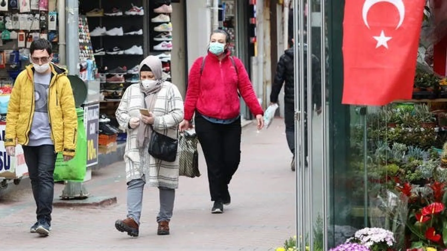 Pedestrians wearing facemasks walk on a street in Ankara on March 30, 2020. (AFP)
