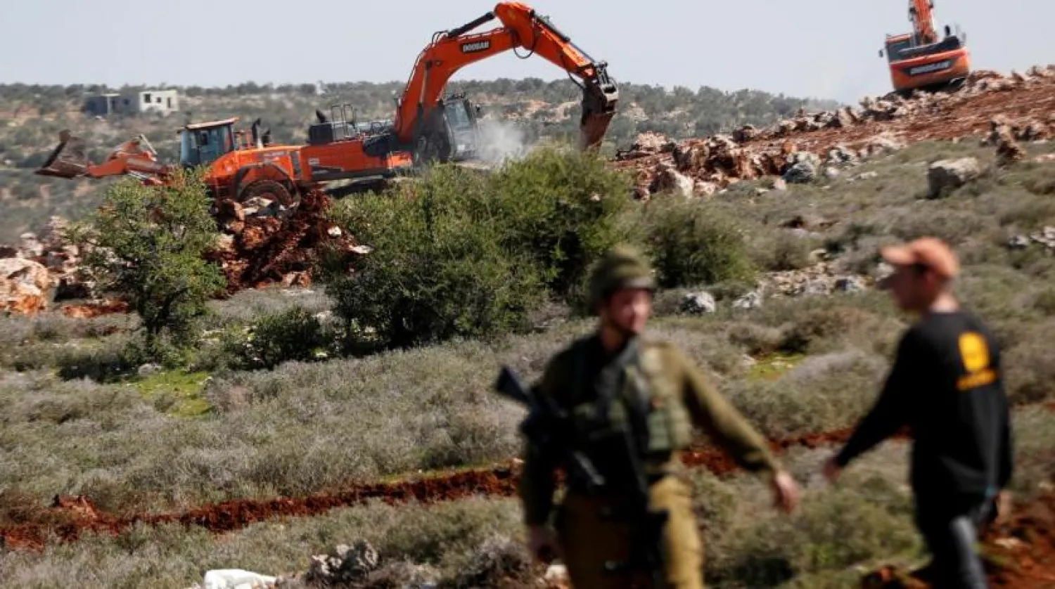 Israeli machineries, guarded by Israeli forces, bulldoze lands near the Palestinian village of Qusra, in the Israeli occupied West Bank, March 3, 2020. (Reuters)
