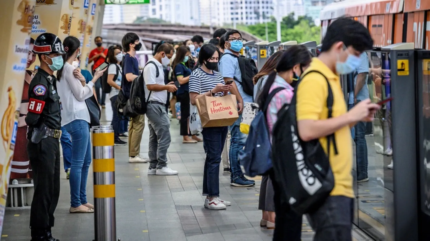 Passengers attempt to observe social distancing as a preventive measure against the spread of the COVID-19 as they wait for a commuter train in Bangkok on May 8, 2020. (AFP)