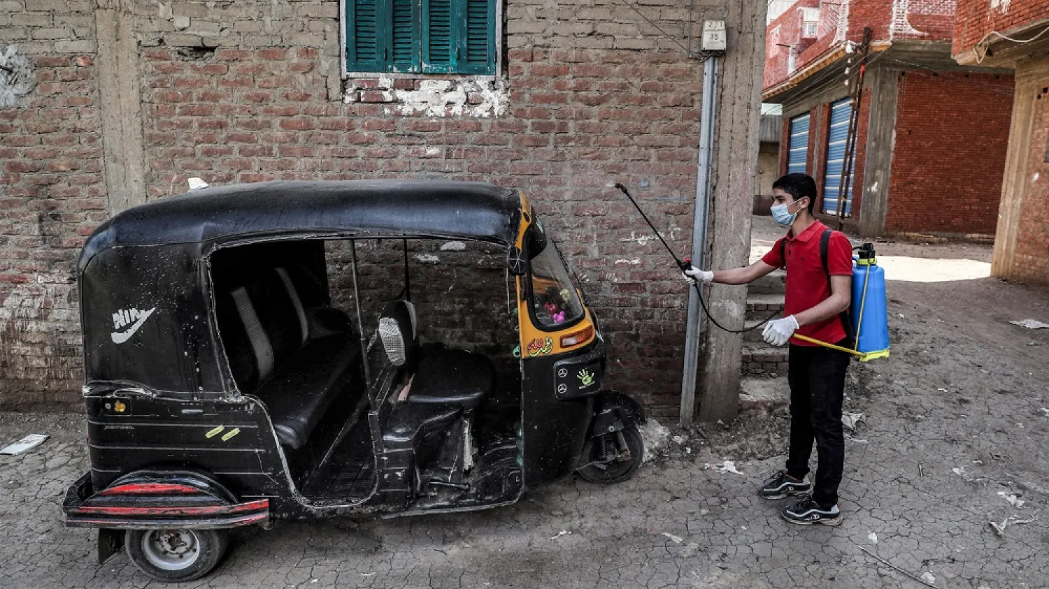 A volunteer disinfects a tuk-tuk as a measure against COVID-19, in the village of Shamma in Egypt's Monufia province on April 1, 2020. (Getty Images)