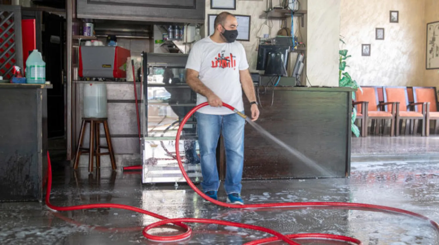 أردني ينظف أرضية مطعمه قبل إعادة فتح أبوابه في عمّان أمس (إ.ب.أ)