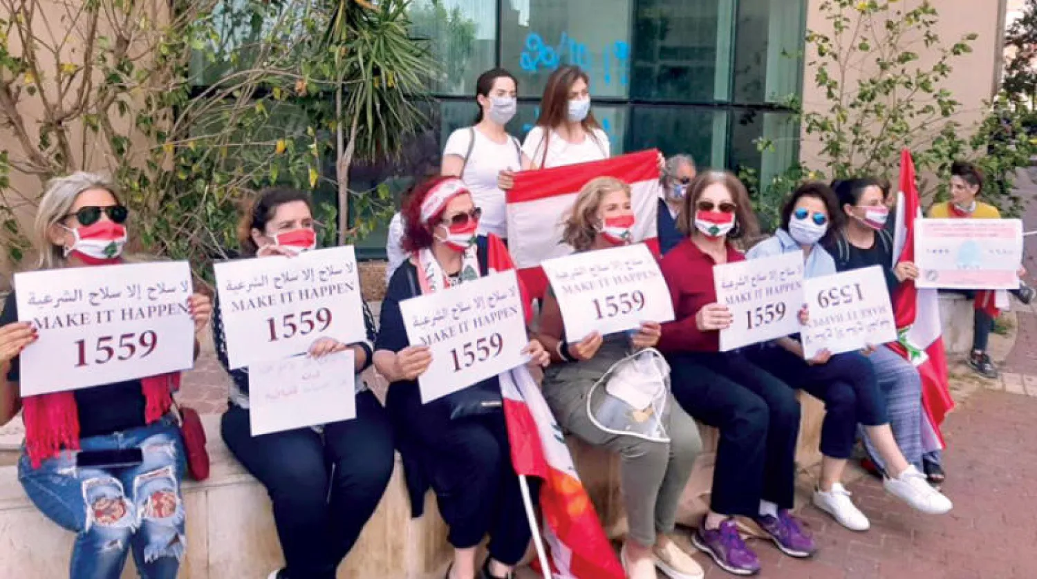 مشاركات في احتجاجات وسط بيروت أمس يرفعن لافتات ضد سلاح «حزب الله» (الشرق الأوسط)