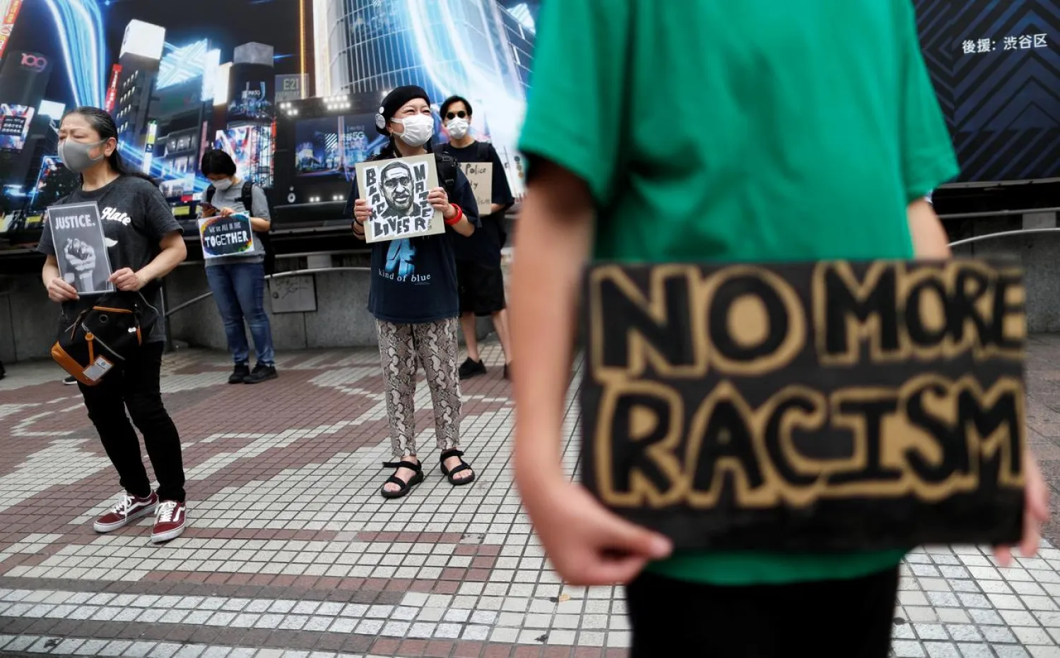 People wearing masks hold placards during a Black Lives Matter protest, following the death of George Floyd who died in police custody in Minneapolis, at Shibuya shopping and amusement district in Tokyo, Japan June 6, 2020. REUTERS/Issei Kato