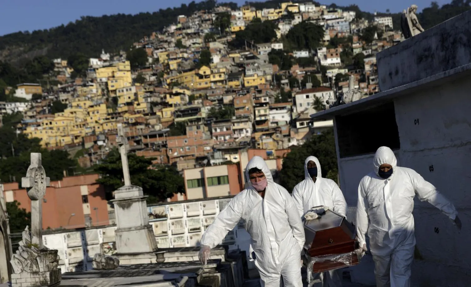Gravediggers carry the coffin of a Brazilian man who passed away from the coronavirus disease (COVID-19) in Rio de Janeiro, Brazil, May 18, 2020. REUTERS/Ricardo Moraes