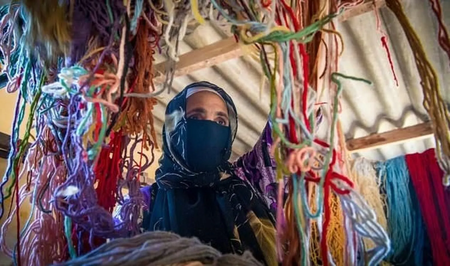 A Moroccan rug weaver sorts through yarn. AFP