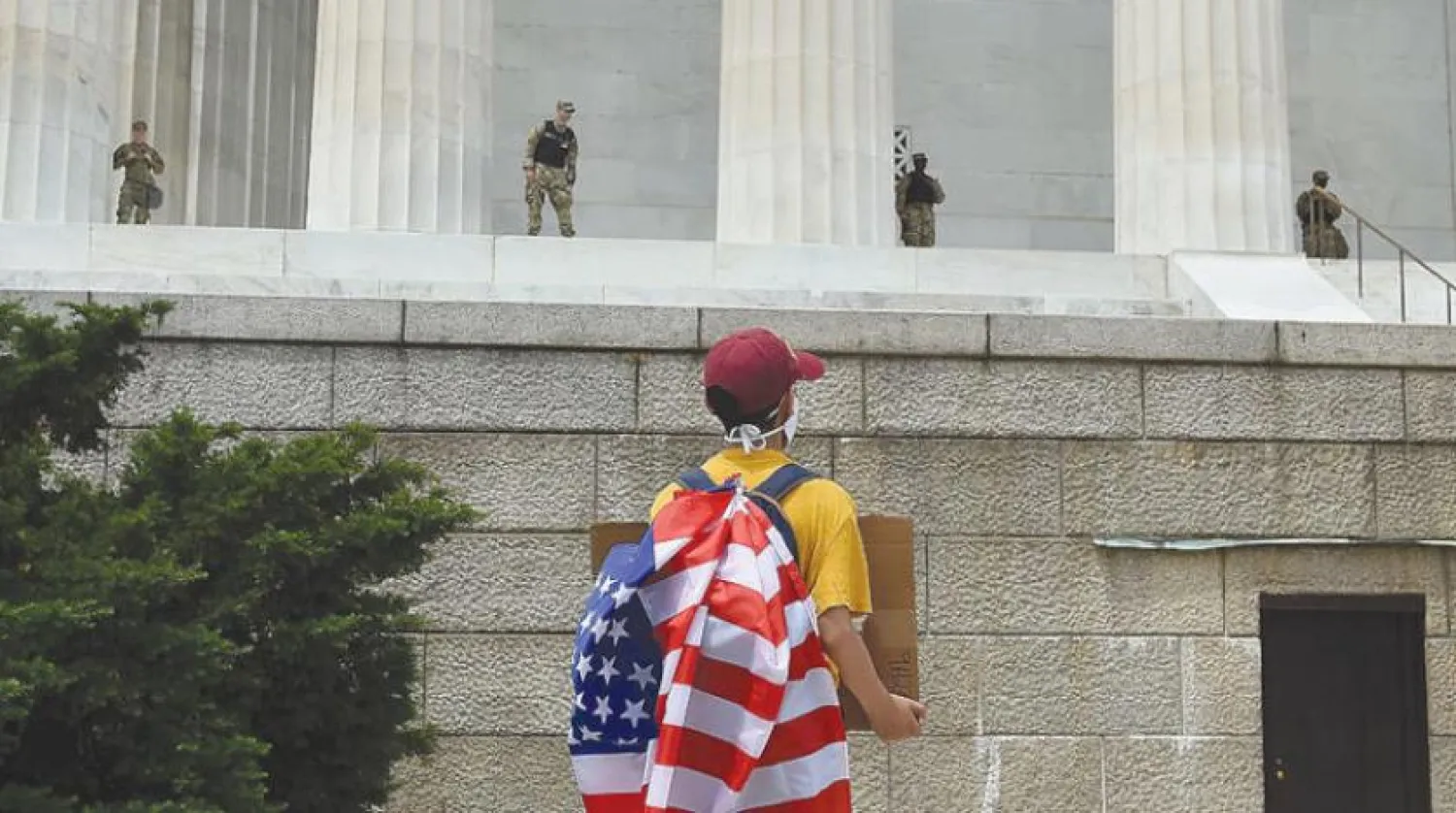 Washington'daki ırkçılık karşıtı protestolar sırasında Lincoln Anıtı’nı koruyan Ulusal Muhafız güçlerinin karşısında duran bir gösterici (AFP)