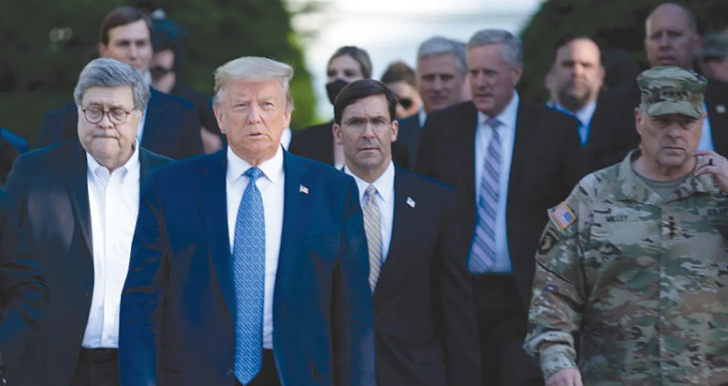 الجنرال ميلي (يمين) يرافق الرئيس من البيت الأبيض إلى الكنيسة في زي قوات الحرس الوطني (أ.ف.ب)