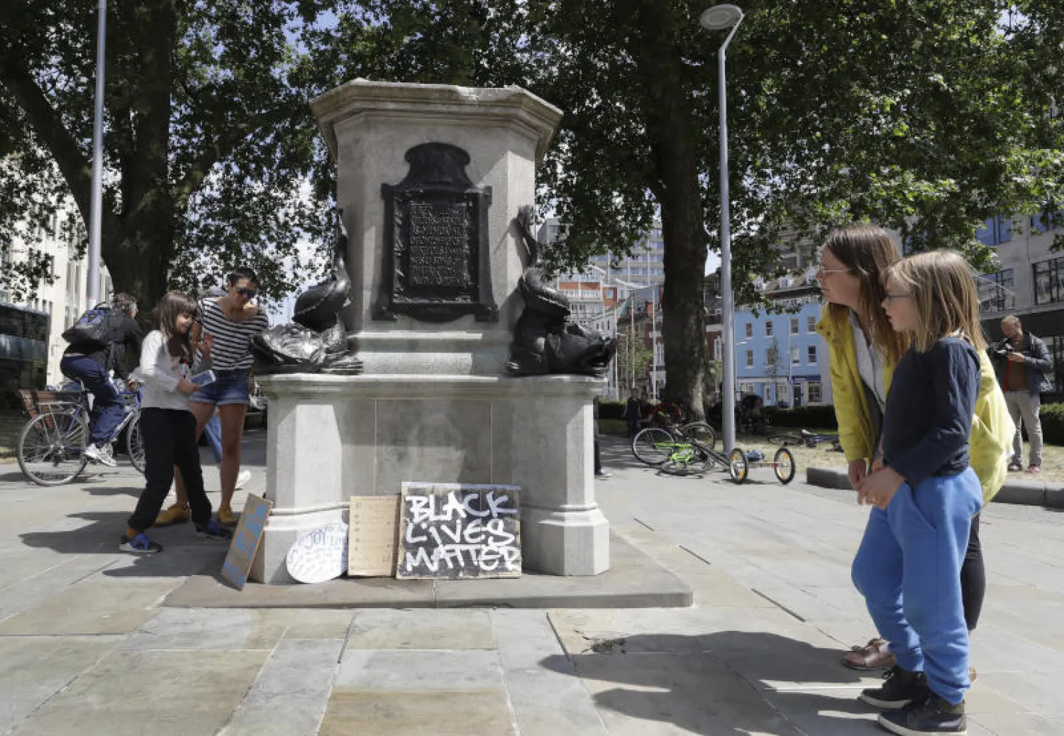 سيدتان تنظران إلى قاعدة تمثال إدوارد كولستون في بريستول البريطانية (أ.ب)