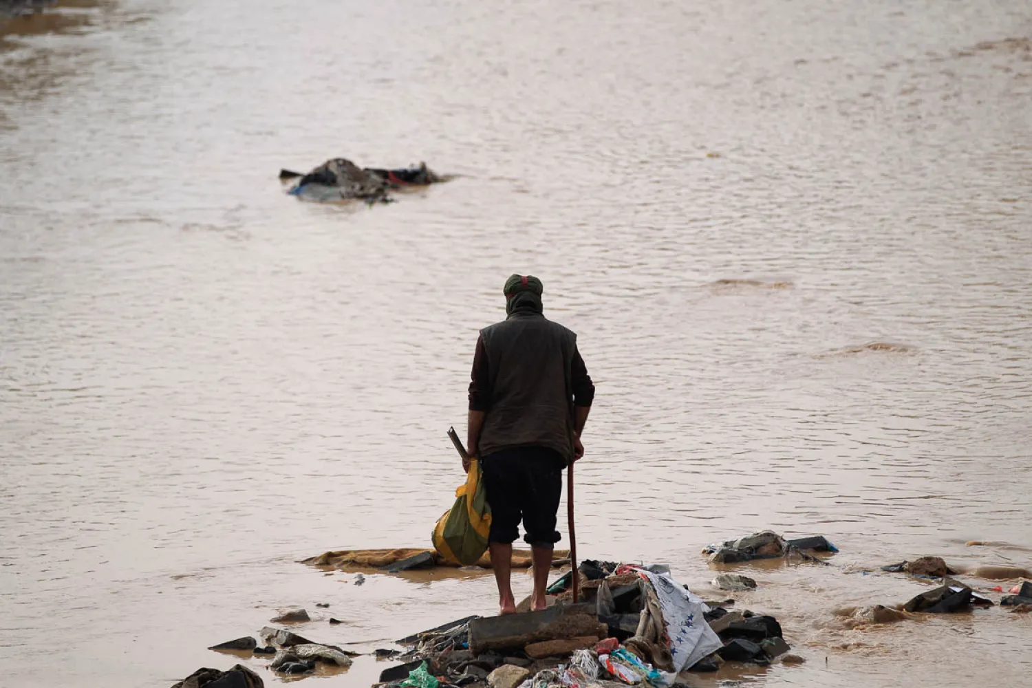 A man collects some goods washed away by the torrents following heavy rains in the Yemeni capital, Sanaa. (AFP)