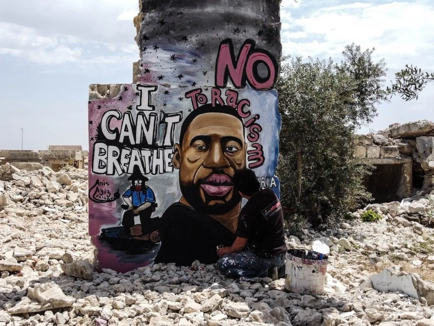Artists Aziz Asmar and Anis Hamdoun paint a mural of George Floyd on ruins in Idlib, Syria. (Getty Images)