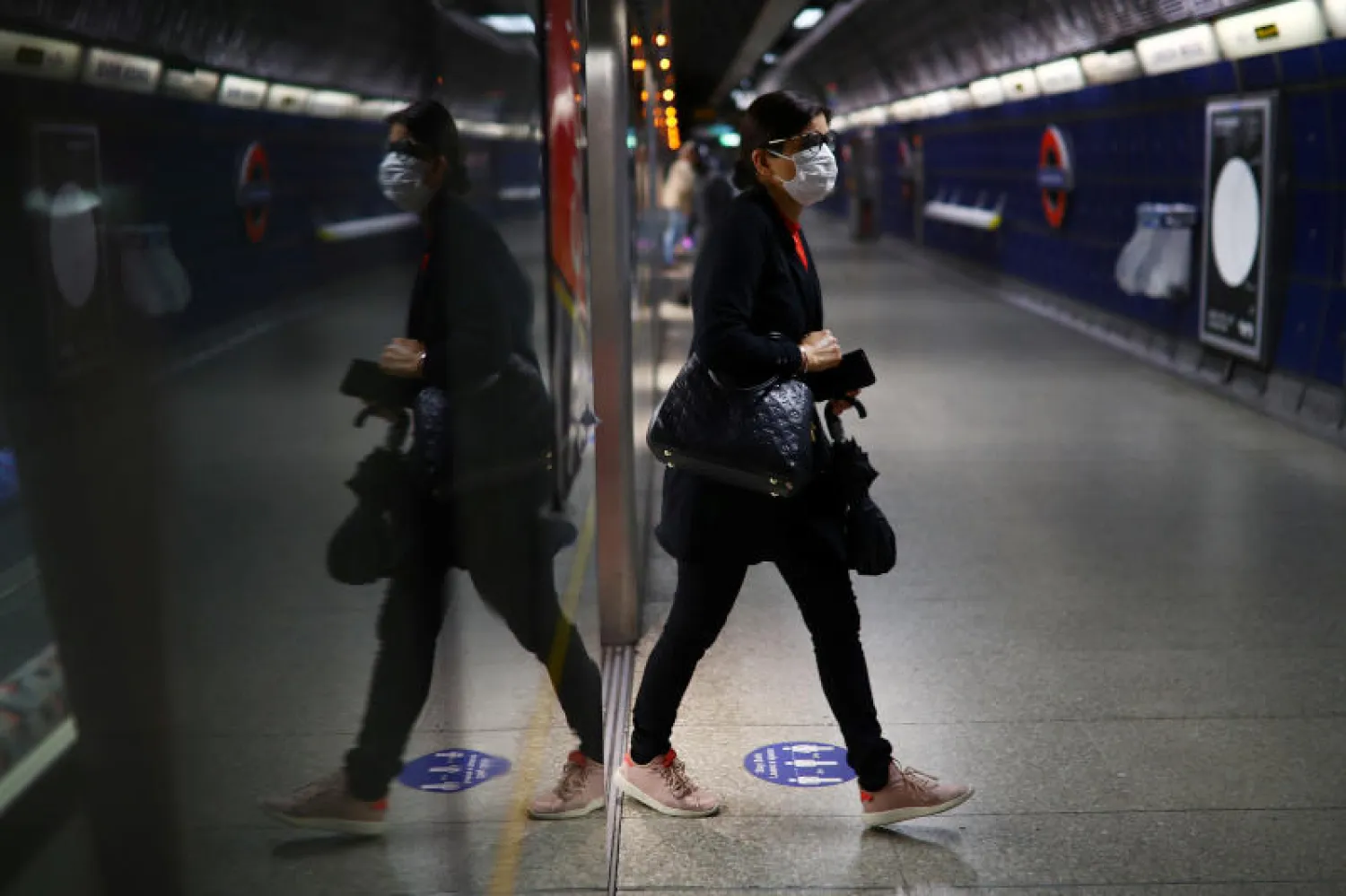 سيدة ترتدي قناع الوقاية في مترو لندن (رويترز)