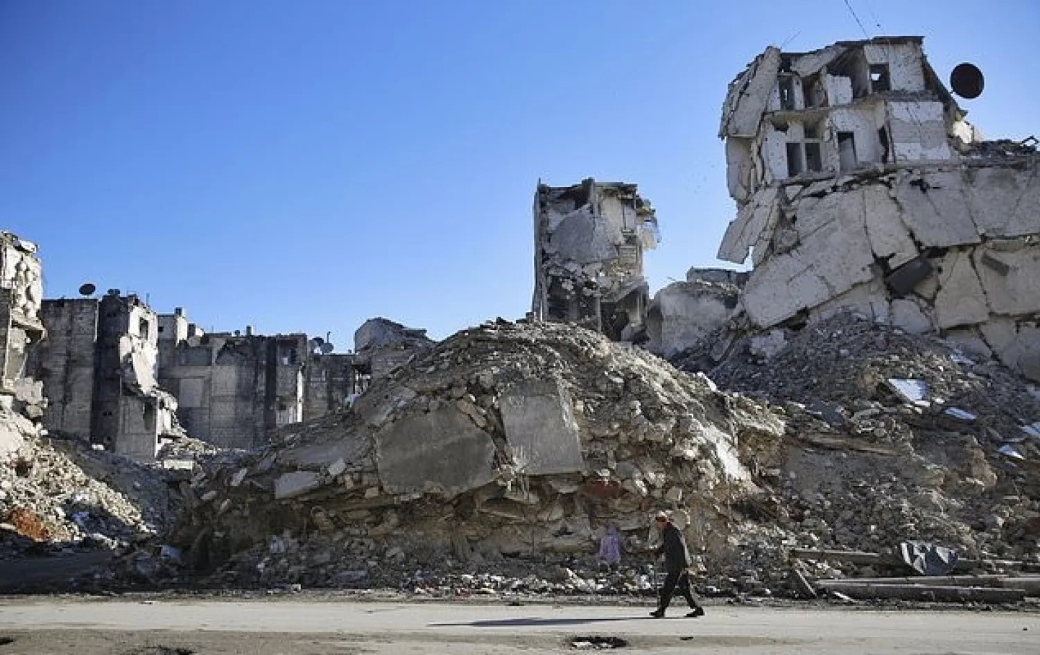 FILE - In this Jan. 20, 2018 file photo, a Syrian man walks through the destruction of the Salaheddine neighborhood in the eastern Aleppo, Syria.  (AP Photo/Hassan Ammar, File)

