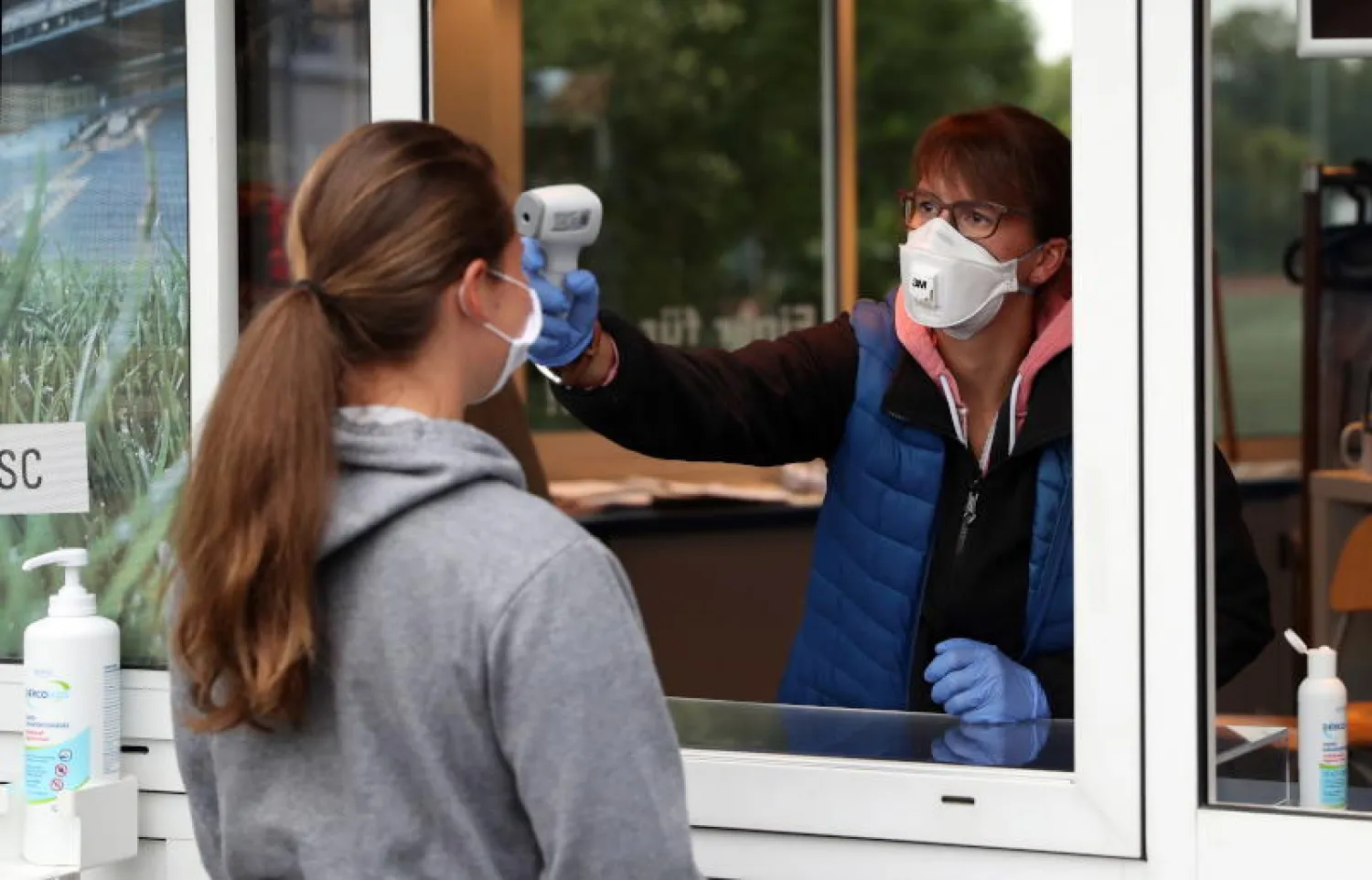 عاملة تخضع لقياس درجة حرارتها في مدينة بيليفيلد الألمانية (ي.ب.أ)