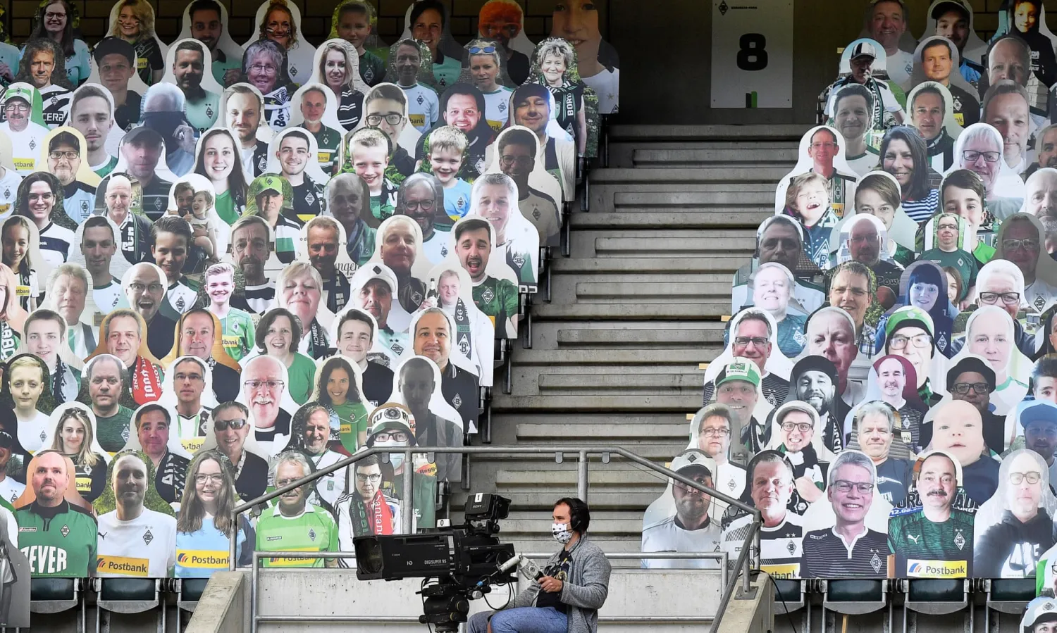 A TV cameraman wearing a face mask is physically distanced as he sits in front of the cutouts of fans during the match between Borussia Mönchengladbach and Union Berlin in May.
Photograph: Martin Meissner/EPA