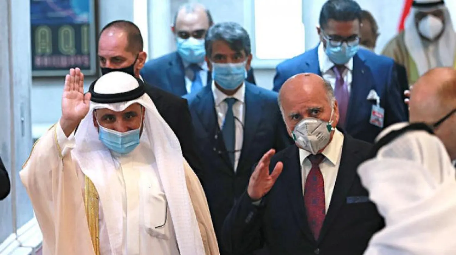 Iraqi Foreign Minister, Fouad Hussein, center right, leaves the meeting room with his Kuwaiti counterpart, Sheikh Ahmed Al-Nasser Al-Sabah, center left, in Baghdad, Iraq, Sunday, June 14, 2020. (AP Photo/Hadi Mizban)