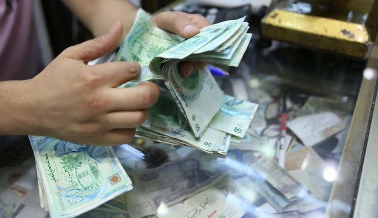 A shopkeeper counts money in his shop at a bazaar in Tunis, Tunisia August 10, 2016. (Reuters)