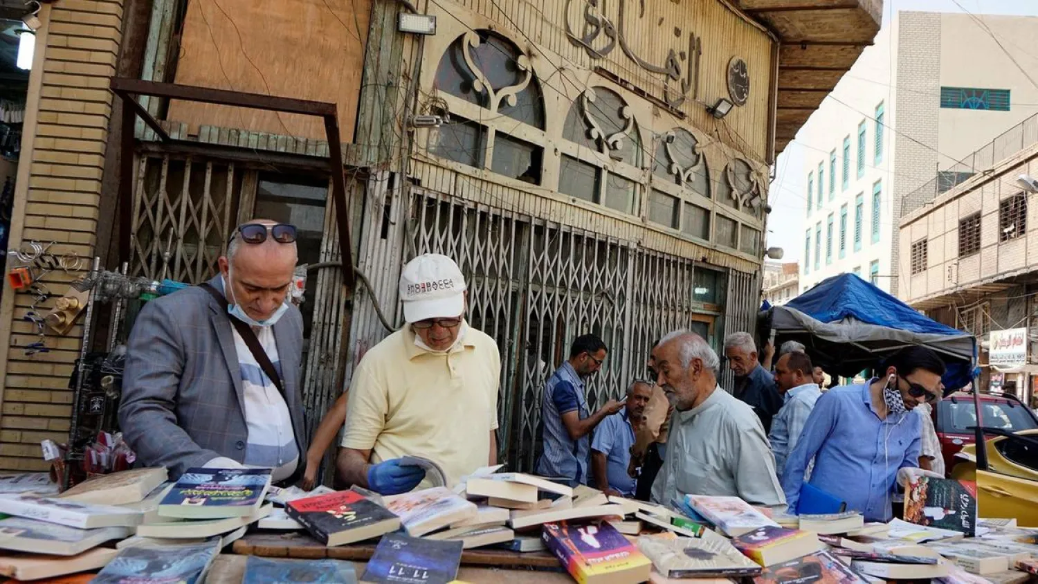 Iraqis check out books sold by a vendor in central Baghdad, April 22, during the coronavirus pandemic. (AFP)