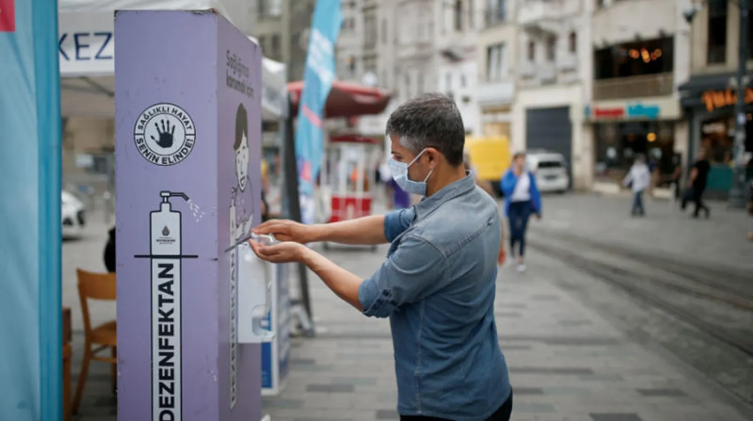 رجل يعقّم يديه في شارع الاستقلال بإسطنبول أمس (أ.ب)