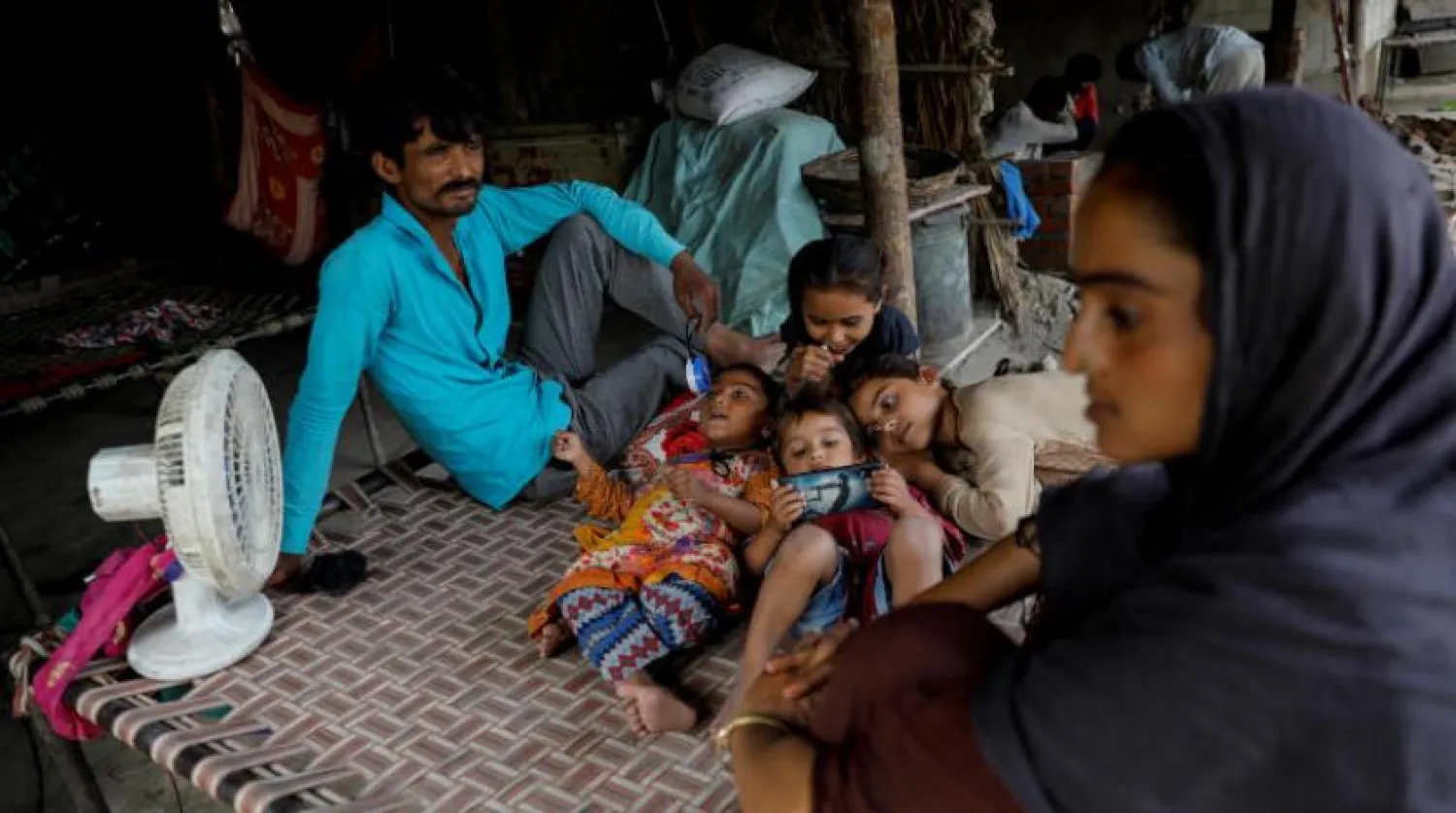 Pakistan Yeni Delhi'de yerinden edilmiş insanlar için bir kampta otururken (Reuters)