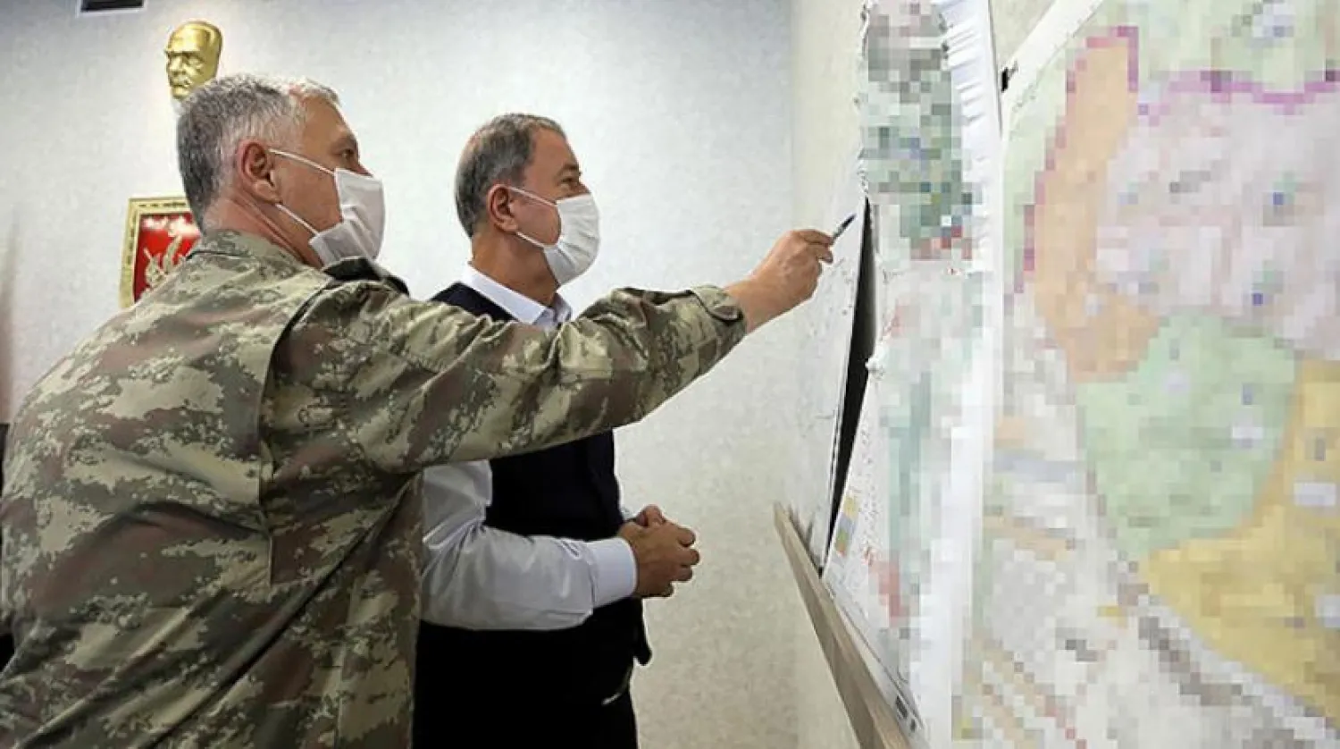 A handout image made available by the Turkish Ministry of Defense Press Office on June 17, 2020, shows the Turkish Minister of Defense Hulusi Akar (R) looking at a map with members of the Turkish Armed Forces Command during a meeting at the Army Command Control Center in Ankara during the military operation dubbed "Claw-Tiger" on June 17, 2020. AFP PHOTO /Turkish Ministry of Defense Press Office 