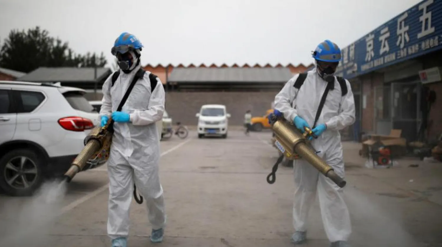 Gönüllüler, yeni bir koronavirüs dalgasının ardından Çin'in başkenti Pekin'de bir pazarı sterilize ederken (Reuters)