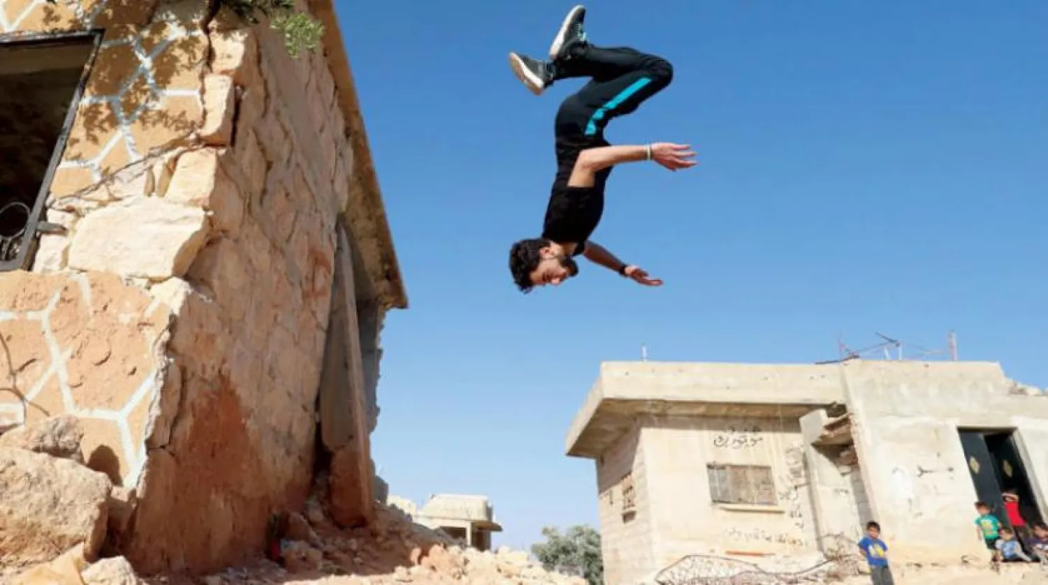A Syrian boy jumps mid-air in Binnish, Idlib countryside, Syria. AP