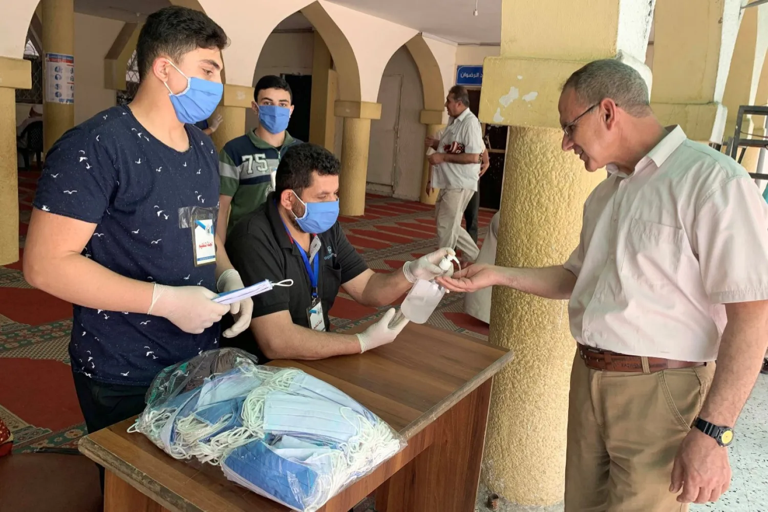 A Palestinian worshipper arriving to attend Friday prayers in a mosque has his hand sanitized as the holy places reopen to worshippers to perform the weekly Islamic ritual, amid concerns about the spread of the coronavirus disease, in Gaza City on May 22, 2020. (Reuters)