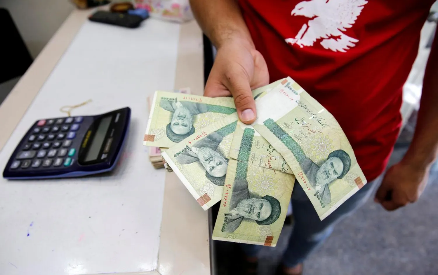 A vendor inspects Iranian rials at a currency exchange shop in Baghdad, Iraq August 8, 2018. (Reuters)