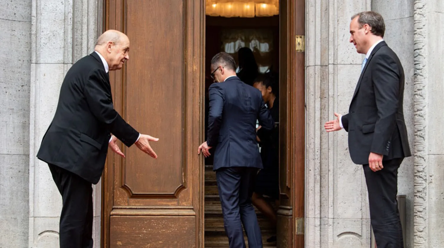 وزيري خارجية فرنسا وبريطانيا في مجاملة قبل الدخول إلى مفاوضات، ويسبقهما وزير الخارجية الألماني في برلين أمس (د.ب.أ)