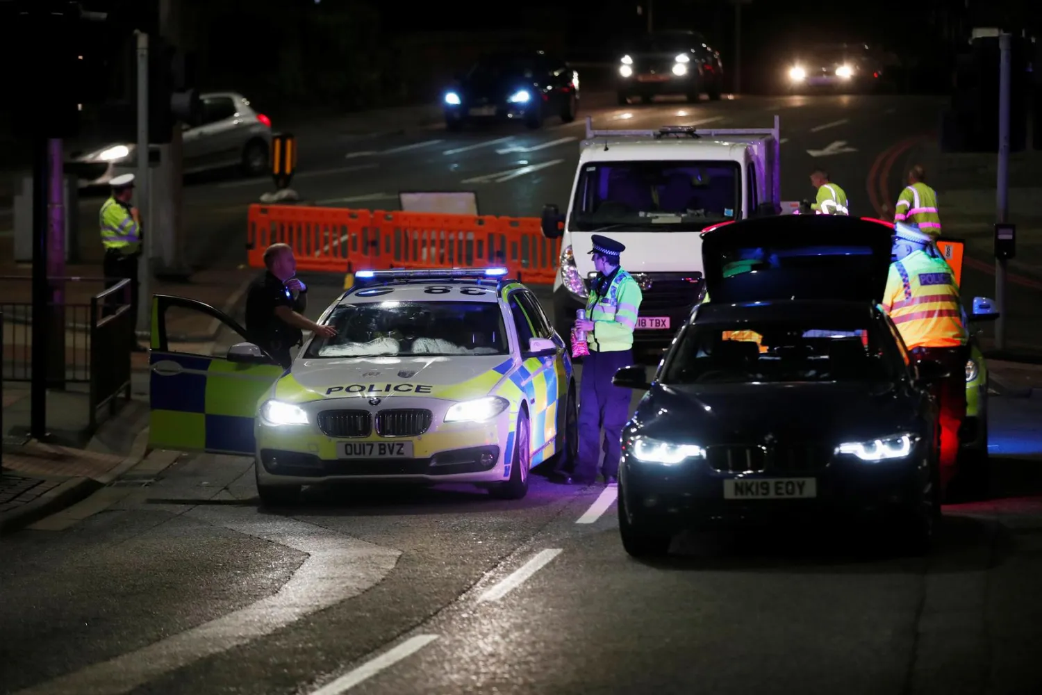 Police officers and their vehicles are seen at the scene of reported multiple stabbings in Reading, Britain, June 20, 2020. REUTERS/Peter Cziborra