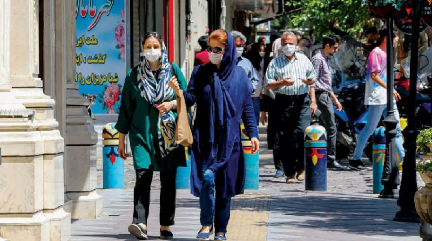 إيرانيون يعبرون شارعاً وسط المركز التجاري لطهران أمس (أ.ف.ب)