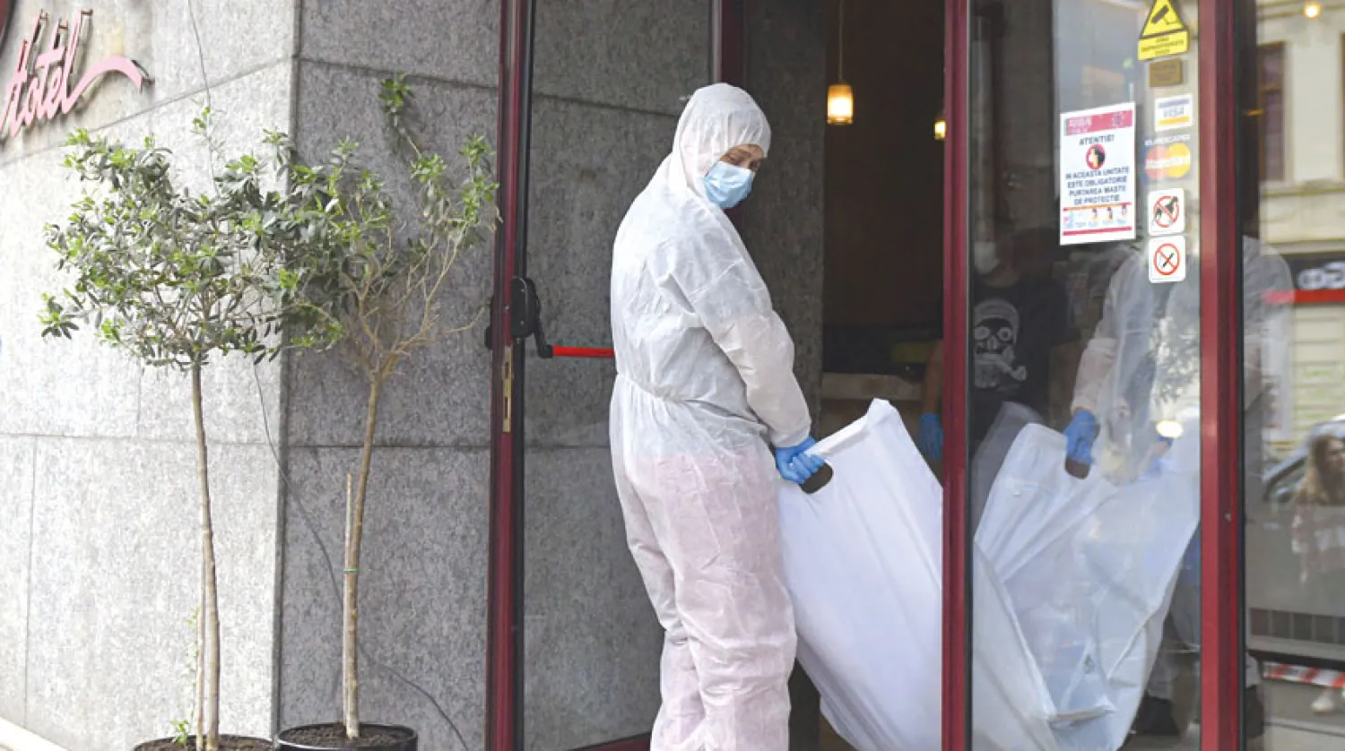 محققون يحملون جثة القاضي الإيراني بعد ساعات من العثور عليها أسفل فندق في بوخارست الجمعة(أ.ب)