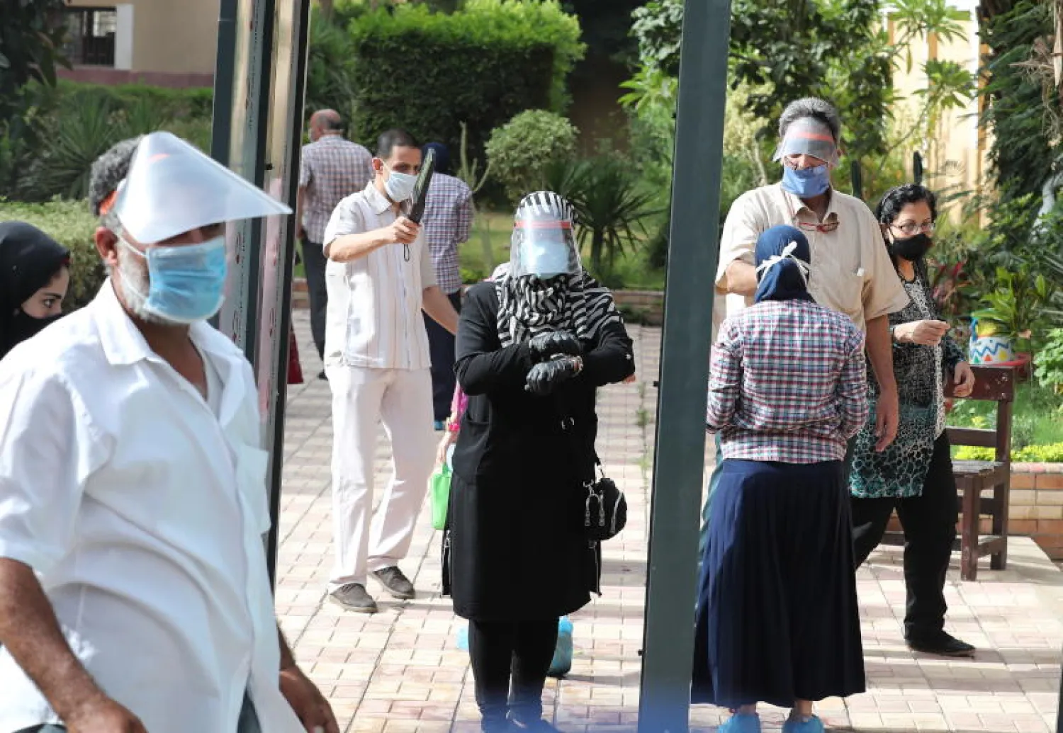 فحص درجة حرارة الطلاب قبل أدائهم امتحان الثانوية العامة بمدرسة في القاهرة (رويترز)
